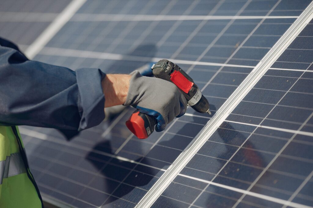 man with white helmet near solar panel scaled 1